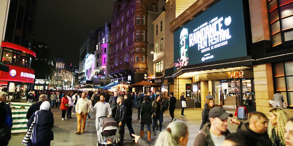 Busy London street with a billboard promoting Raindance Film Festival