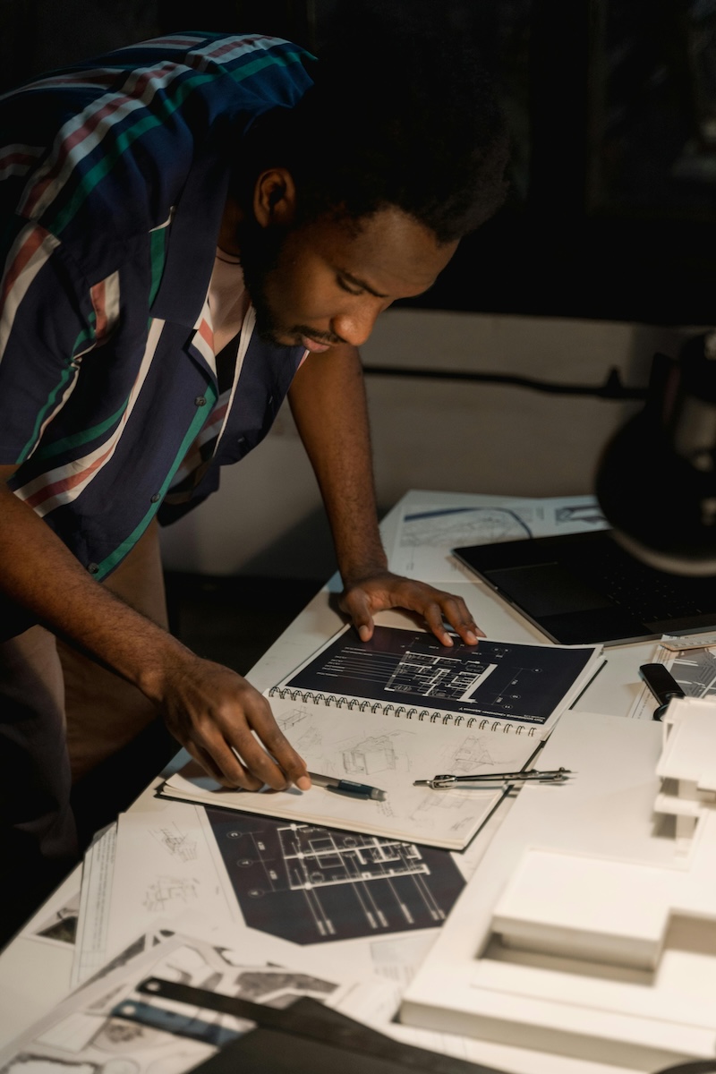 image of a man leaning over a desk as he works on set design 